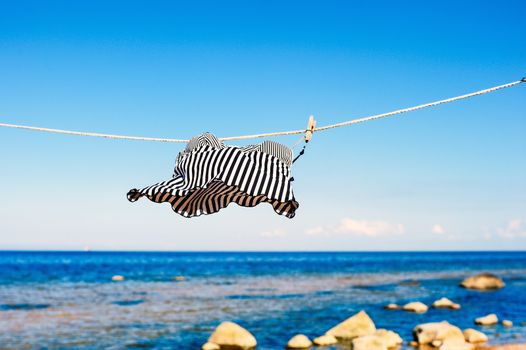 Striped top hanging on a rope on the beach