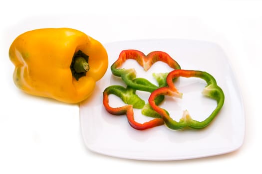 Pepper slices on plate on white background