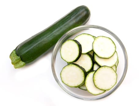 Zucchini slices on bowl on white background viewed from above