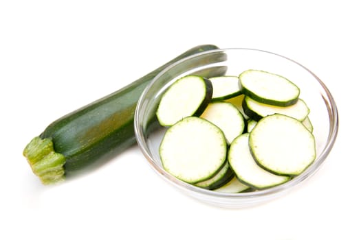 Zucchini slices on bowl on white background