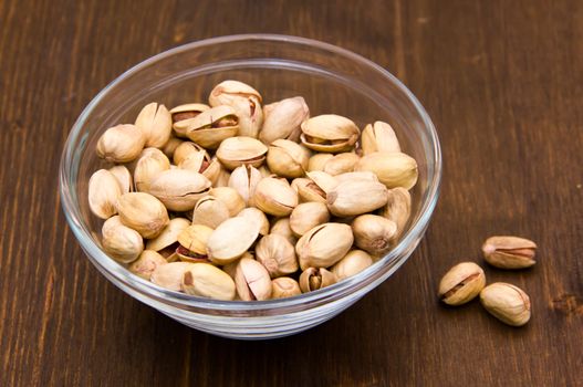 Pistachios on glass bowl on wooden table