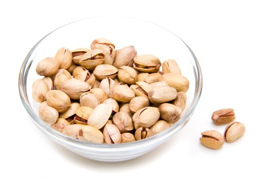 Pistachios on glass bowl on white background