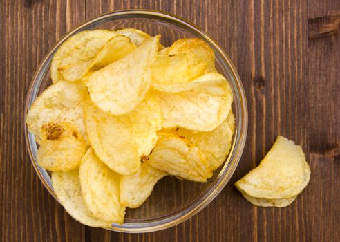 Bowl of chips on wooden table top view