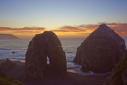 Colourful sunset over the pacific ocean at the coastal town of Constitucion in Maule, Chile. In the foreground are the Rocas de los Calabocillos, which are home to thousands of seabirds.