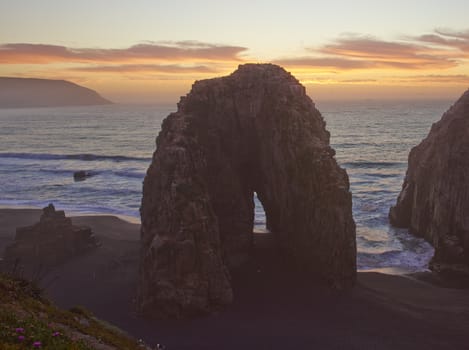 Colourful sunset over the pacific ocean at the coastal town of Constitucion in Maule, Chile. In the foreground are the Rocas de los Calabocillos, which are home to thousands of seabirds.