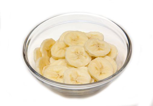 Banana slices on bowl on white background
