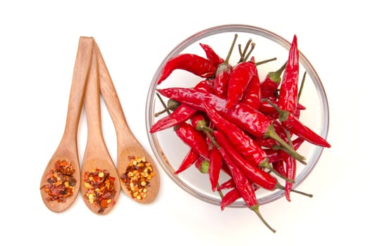 Peppers on the bowl and spoons on a white background seen from above