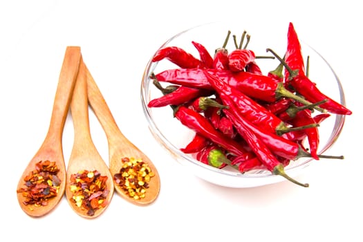 Peppers on the bowl and spoons on a white background