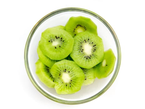 Slices of kiwi fruit on bowl on white background viewed from above