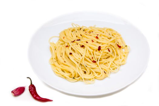 Spaghetti with garlic and chili peppers on white background