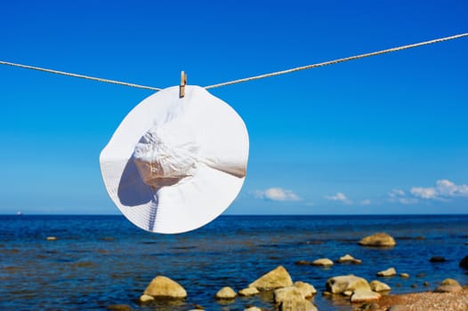 Hat from the sun hanging on a rope on the coast