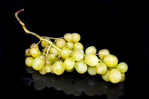 Bunch of grapes reflected on black background