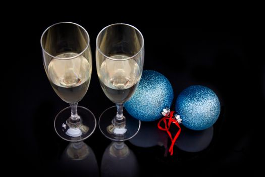Flute and christmas balls which are reflected on a black background