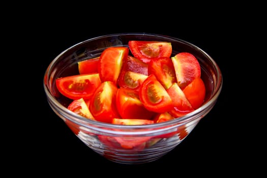 Bowl of tomato wedges on a black background