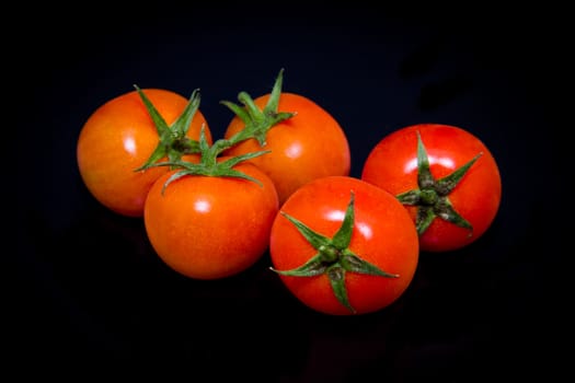 Fresh cherry tomato on a black background