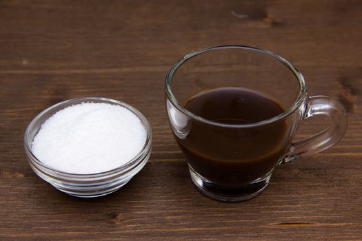 Cup of coffee and sugar on wooden table