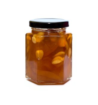 Peach jam glass jar reflected on white background