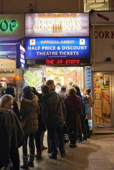LONDON, UK - JANUARY 02: People lined up for discounted theatre tickets at night in Leicester Square. January 02, 2015 in London.