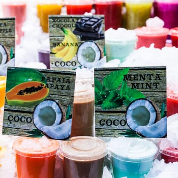 Detail of fresh fruit juices ready to be sold in a busy market.