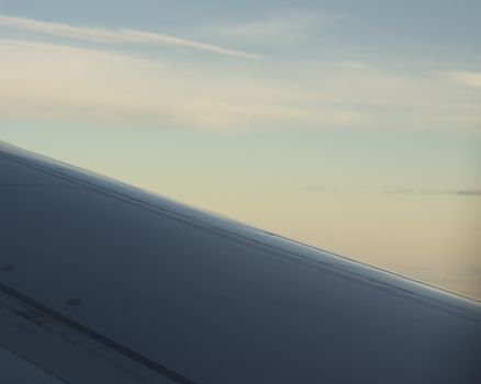 Airplane flying in sky in flight metal wing.