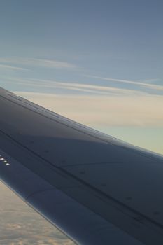 Airplane flying in sky in flight metal wing.