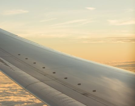 Airplane flying in sky in flight metal wing.