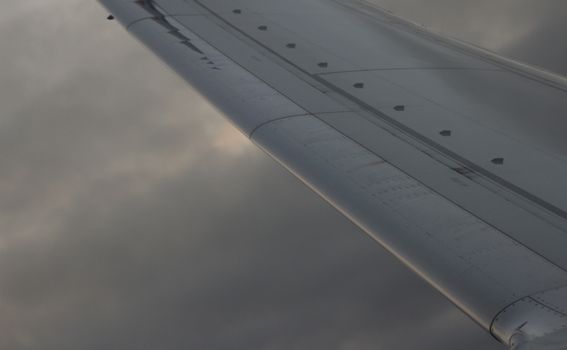 Airplane flying in sky in flight metal wing.