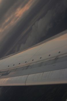 Airplane flying in sky in flight metal wing.