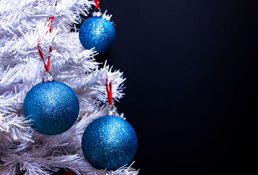 Christmas balls on tree with white branches to close