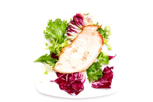 Chicken and salad on plate on white background seen from above