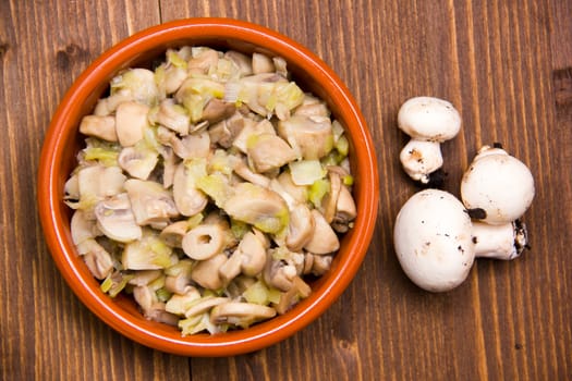 Grilled Mushrooms on bowl on wooden table seen from above