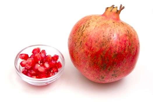 Pomegranate with grains seen up close on a white background