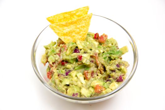 Guacamole in glass bowl on white background