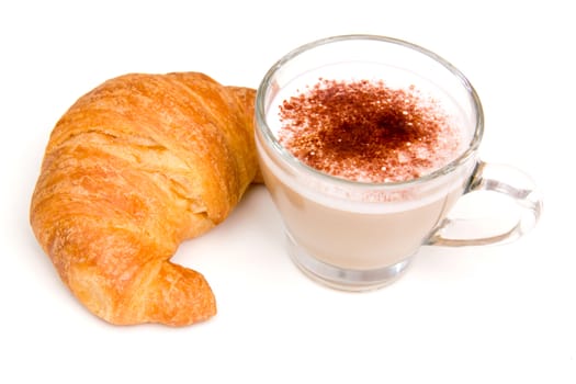 Cappuccino and croissant seen up close on a white background