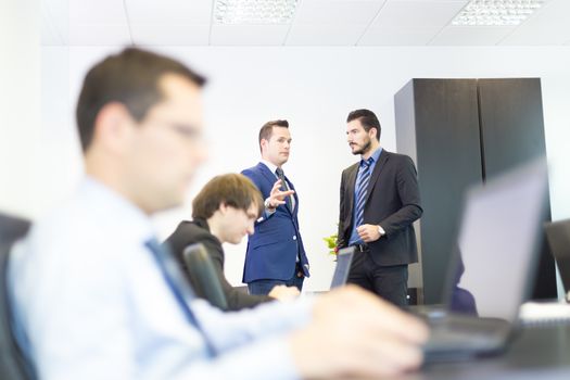 Workplace in modern office with business people brainstorming. Businessman working on laptop during the meeting.