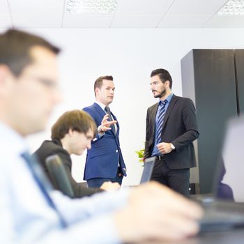 Workplace in modern office with business people brainstorming. Businessman working on laptop during the meeting.