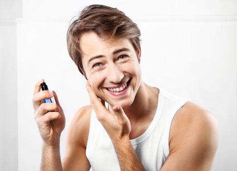 Young handsome man after shave balm is applied on the skin face