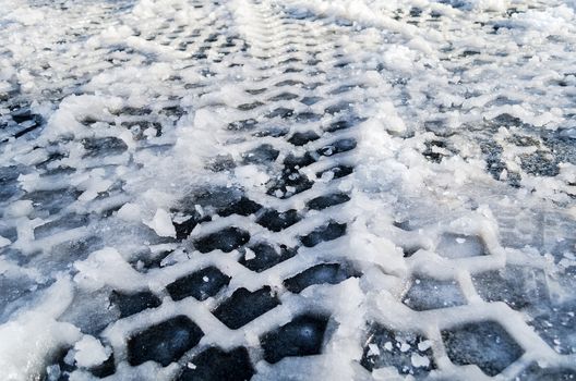 Close up of tire track in snow and ice ground