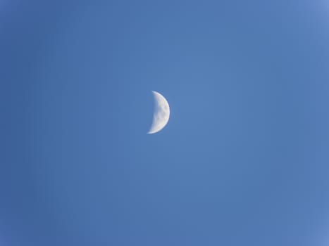 A half moon in the blue sky