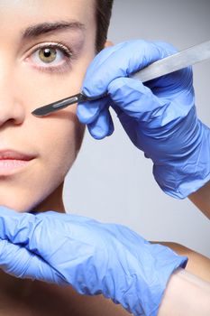 Caucasian woman during surgery using a scalpel