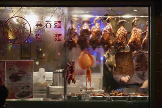 LONDON, UK - JANUARY 02: Detail of Chinese restaurant with traditional crispy ducks hanging on foggy display window in Chinatown at night. January 02, 2015 in London.