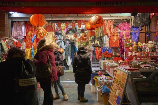LONDON, UK - JANUARY 02: Tourists shopping at traditional Chinese store in Chinatown at night. January 02, 2015 in London.