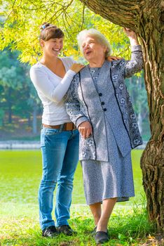 caring and loving granddaughter walking with her grandmother in the park