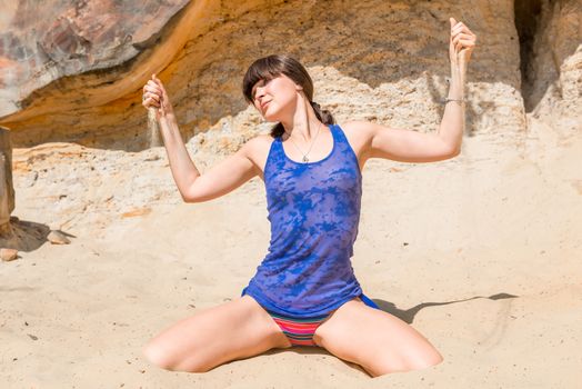 girl pours sand out of the hands on the beach