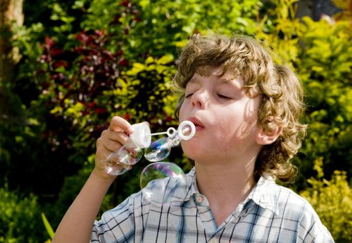 causcasian boy blowing bubbles