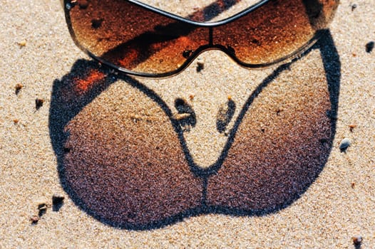 Reflection from plastic sunglasses in the sand