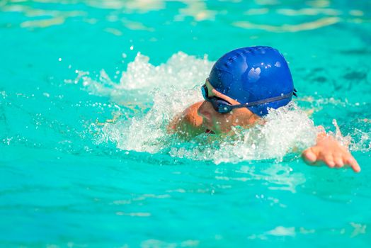 the man quickly swims in the outdoor pool