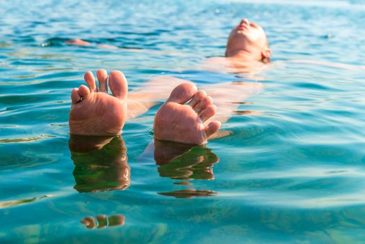 feet with splayed fingers lying on the water man