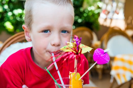 5 years old boy drinking a delicious fruit cocktail