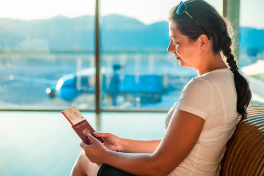 young girl with documents waiting to board the plane